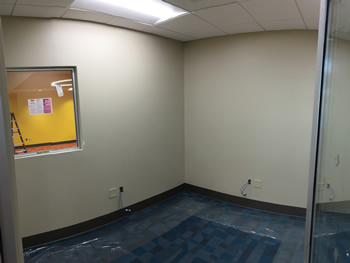 The office for the supervisor of new Empire Library. Includes blue carpet, white walls, and a window that looks into the main area of the library.