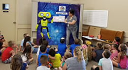 Woman reading a book to a group of children